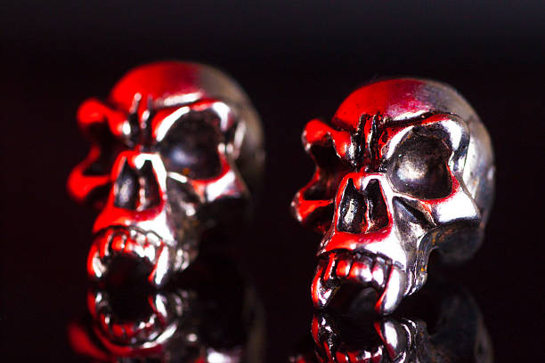 istock two metal skull on a black background 519690540