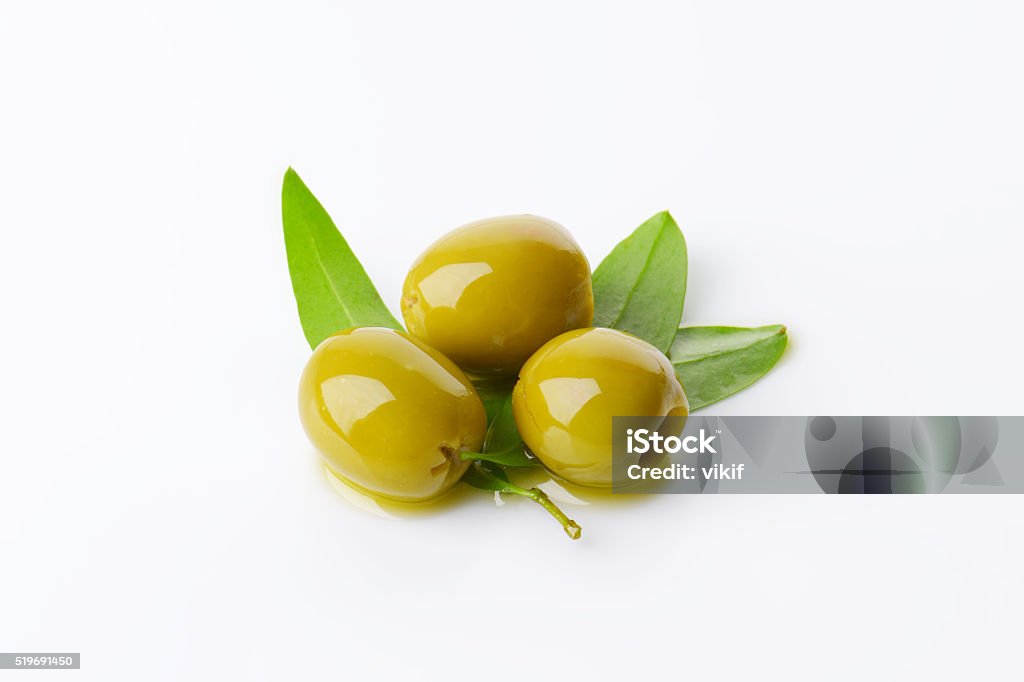 Pitted green olives Three pitted green olives with fresh leaves Appetizer Stock Photo