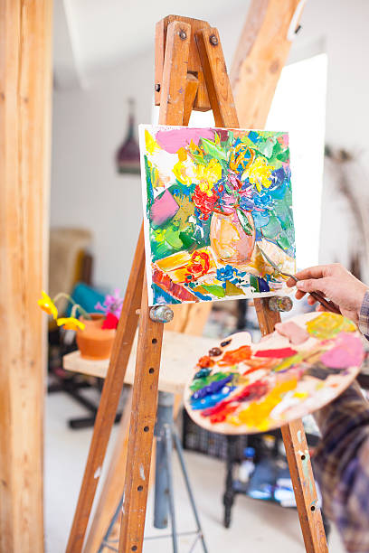 istock Painter's palette and new artwork on easel-vertical 519692118