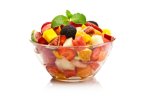 Two glass bowls filled with fresh colorful fruit salad shot on white background.