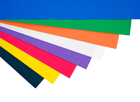 Several different colors of craft paper arranged at an angle on a white background.
