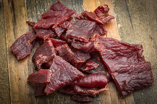 Heap of Beef Jerky over a wooden counter close up