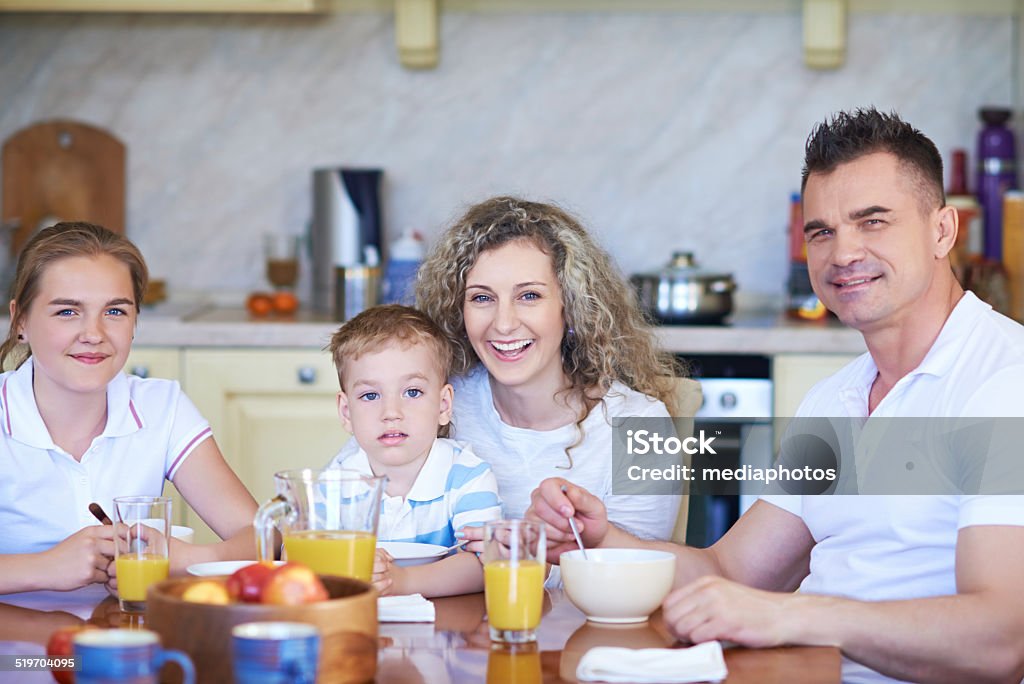 Happy all together Portrait of happy family of four having a breakfast 12-13 Years Stock Photo