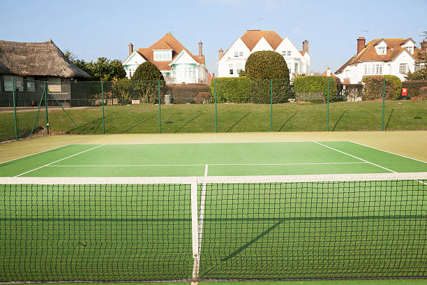 Professional tennis court in sunshine with ball come to rest near to the net