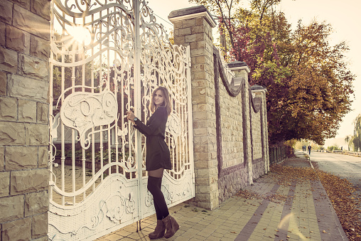 Girl staying in front of big white gates