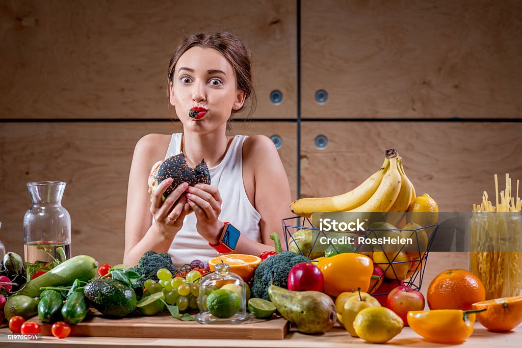 Femme de manger un hamburger à la Tableau des plats équilibrés - Photo de Manger libre de droits