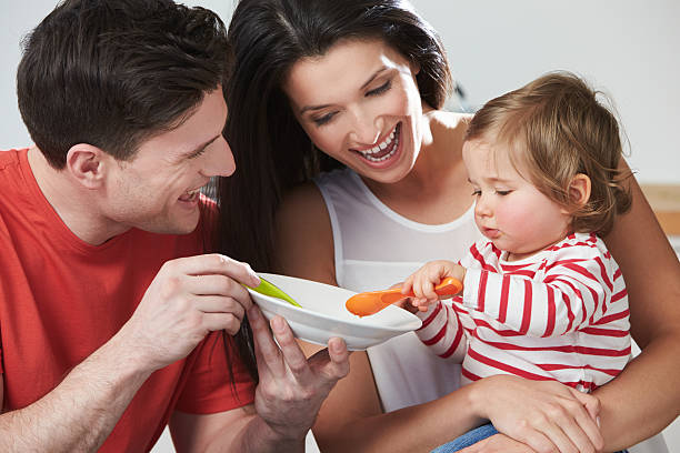 istock Parents Feeding Baby Daughter From Bowl 519706259