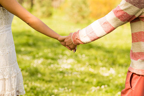 istock Young couple holding hands in park 519707806