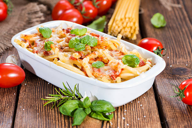 Homemade Pasta Bake Portion of homemade Pasta Bake (with Macaroni) on wooden background pasta casserole stock pictures, royalty-free photos & images