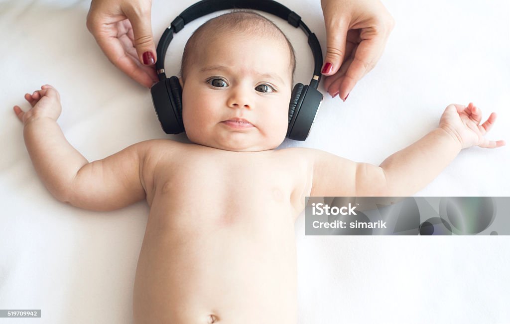 Beautiful Baby on White Towel with Headphone Beautiful baby with headphone on white towel is looking at camera Baby - Human Age Stock Photo