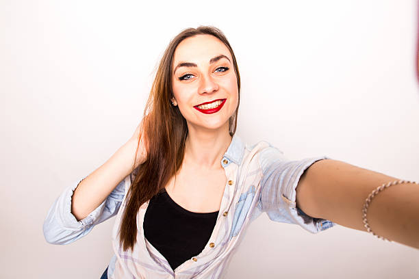 Young beautiful girl taking Selfie picture from hands  over white