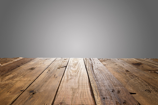 Empty wood table with gray background. Ideal for product display on top of the table.