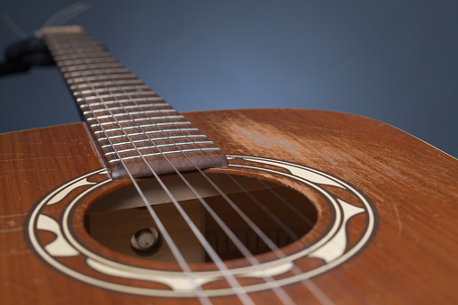 A closeup shot of guitar strings in a room with blurry background