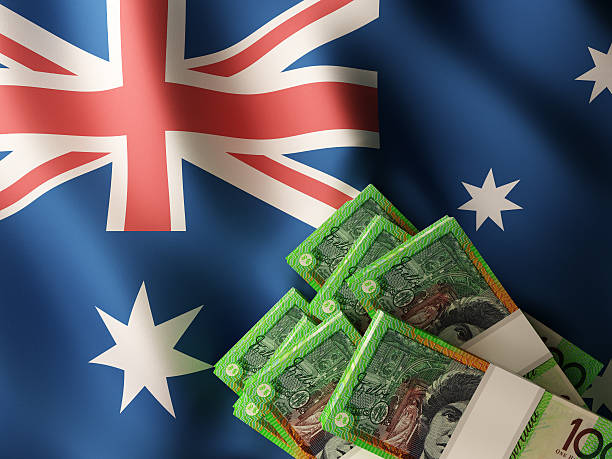 Australian dollar banknotes over Australia flag Australian dollar banknote bundles on textile textured Australia flag. 3d rendered illustration. Highest Paying Jobs in Australia stock pictures, royalty-free photos & images