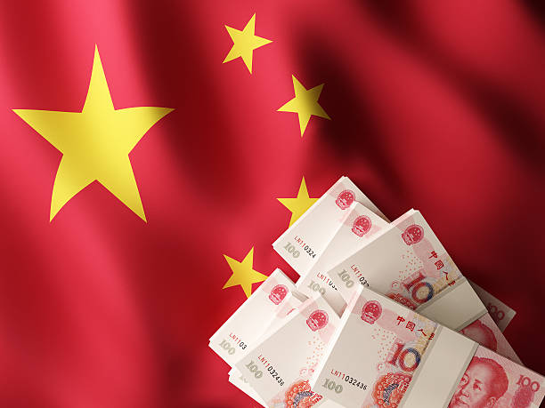 istock Chinese yuan renminbi banknotes over China flag 519716848