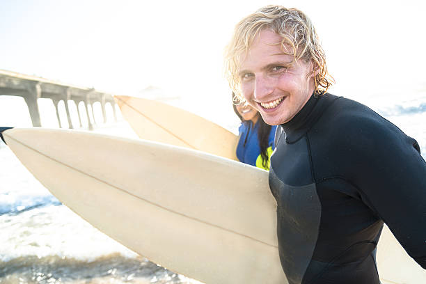 istock group of people embracing at sunset with surfboard 519718420