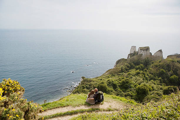 istock Couple Relaxing On Cliff Looking At Ocean View 519722637
