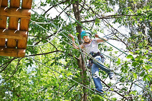 istock Girl is climbing to high rope bridge 519723617