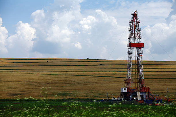 Shale gas drilling rig Color shot of a shale gas drilling rig on a field. natural gas extraction stock pictures, royalty-free photos & images