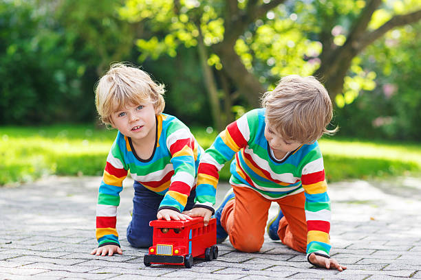 istock Two little kids playing with red school bus 519726439