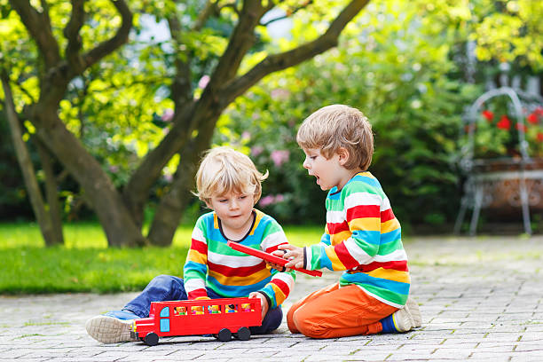 istock Two little children playing with red school bus 519726443