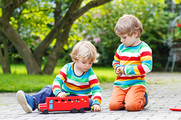 istock Two little friends playing with red school bus 519726451