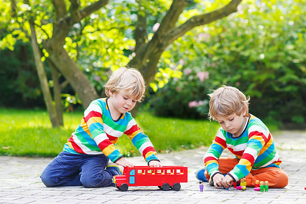 istock Two twin boys playing with red school bus 519726465