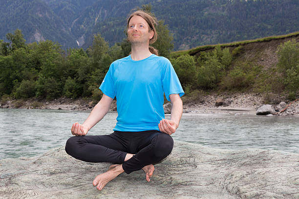 istock Young man doing meditation in Lotus pose outdoors 519726507
