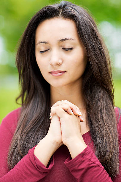 istock Woman praying outdoors 519727231