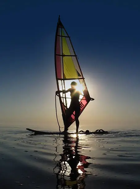 Sea Windsurfing Sport. Windsurfer training at sunset. Summer. Lifestyle concept 