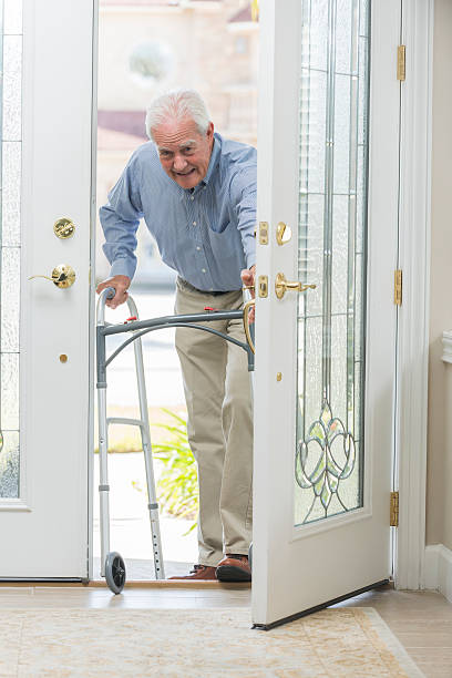 istock Senior man with walking coming home thru front door 519734670