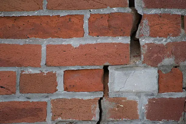 Patched bricks with crumbling mortar in the cracks