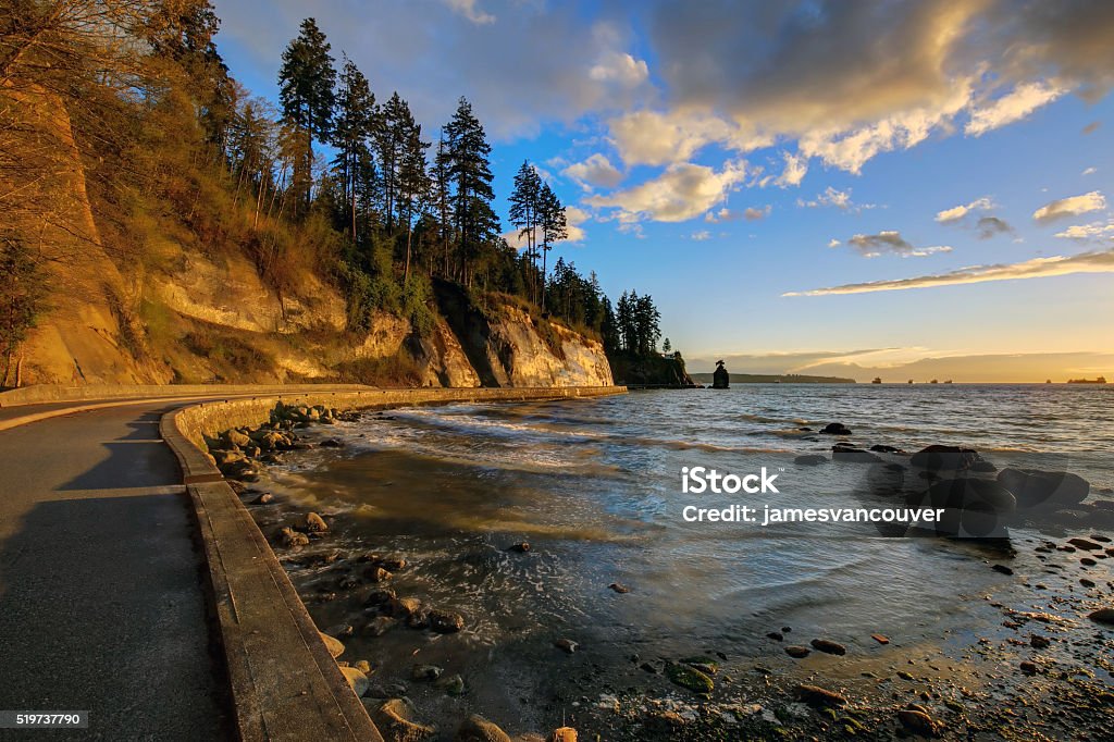 seawall and rock wall at sunset seawall and rock wall at sunset, with famous Siwash Rock in the sea water, Stanley Park, Vancouver, British Columbia, Canada Vancouver - Canada Stock Photo