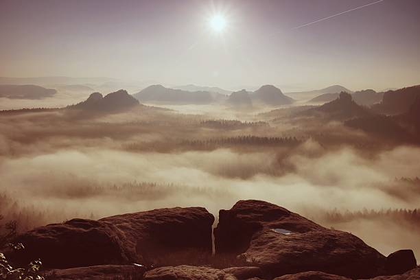 istock Sunrise on top of mountain with view into misty valley 519747110