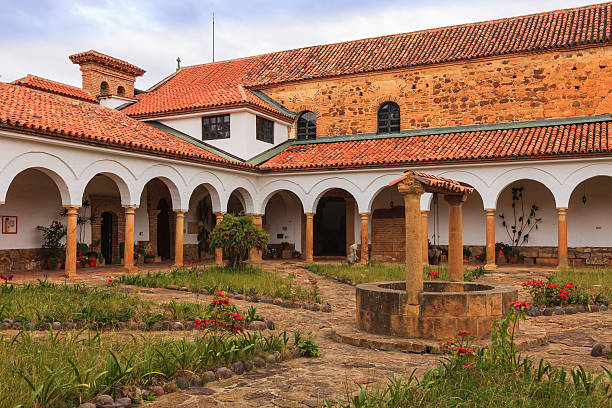 Looking from the courtyard of the Monastry of Santo Ecce Homo towards the old church attached to the monastary. The monastary was founded in 1620; the church was completed in 1661. What looks like a well in the foreground, is actually a tank that stores rain water for use. The buildings are a good example of classic colonial Spanish architecture. In 1998 the monastery was declared a national archtictural heritage. Photos are permitted in every area of the premises.  Photo shot in the midday light on a cloudy day; horizontal format. No people.