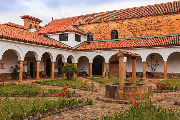 Villa de Leyva, Colombia - Monastary Santo Ecce Homo Looking from the courtyard of the Monastry of Santo Ecce Homo towards the old church attached to the monastary. The monastary was founded in 1620; the church was completed in 1661. What looks like a well in the foreground, is actually a tank that stores rain water for use. The buildings are a good example of classic colonial Spanish architecture. In 1998 the monastery was declared a national archtictural heritage. Photos are permitted in every area of the premises.  Photo shot in the midday light on a cloudy day; horizontal format. No people. boyacá department photos stock pictures, royalty-free photos & images
