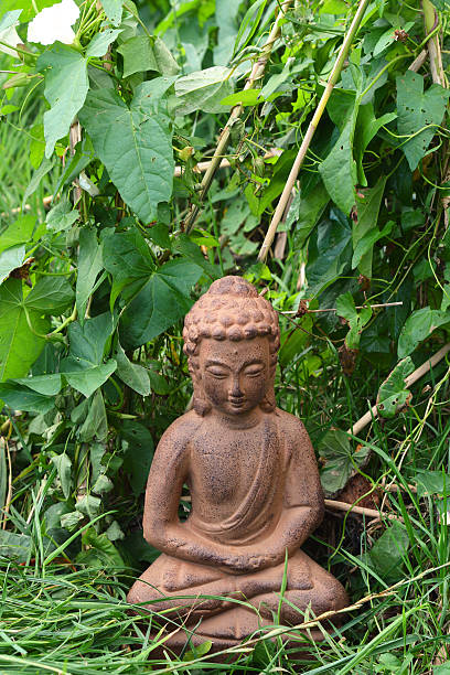 istock Buddha stature in a green garden with reed 519748017