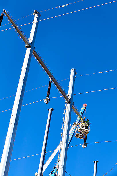 istock High voltage transmission power line tower crane men 519748104