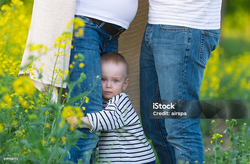 pequeno seu filho segura uma perna da mãe. - Foto de stock de Mãe royalty-free