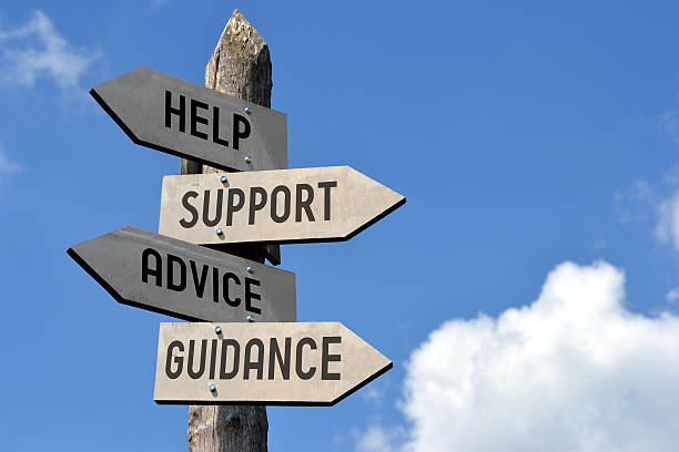 Help, support, advice, guidance signpost Wooden singpost with "help, support, advice, guidance" arrows against blue sky. advice photos stock pictures, royalty-free photos & images