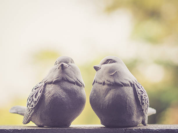 istock Pigeons sculptures with green bokeh; vintage filter 519749120