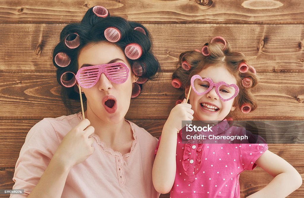 Happy loving family Funny family! Mother and her child daughter girl with a paper accessories. Beauty funny girl holding paper glasses on stick. Beautiful young woman holding paper glasses on stick. Mother Stock Photo