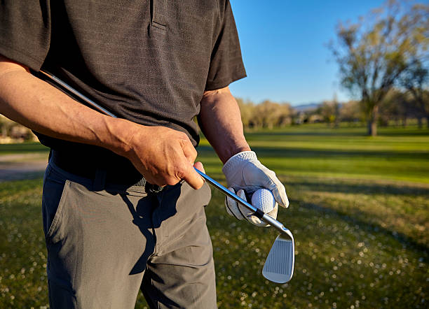 istock Man golfer long iron and ball late afternoon golf round 519749762