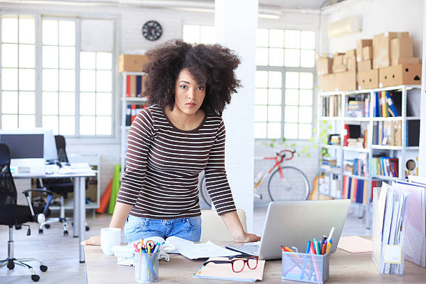 istock Serious young woman leaning on desk at workplace 519751626