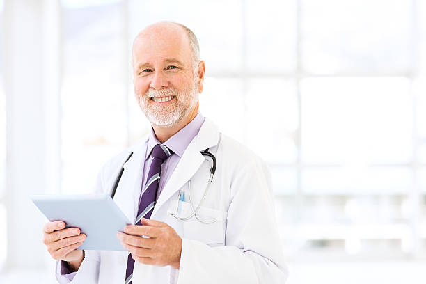istock Smiling Senior Male Doctor Holding Digital Tablet 519752155