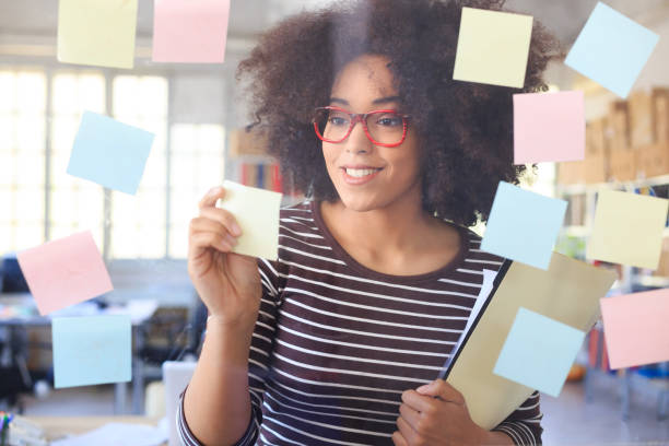 istock Young woman looking at sticky notes 519754396