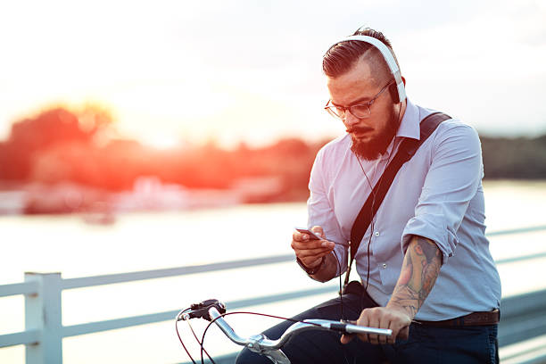 istock Businessman Sitting On Bicycle And Using Smartphone Outdoors. 519754696
