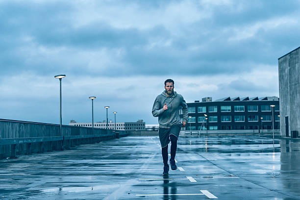 istock Male runner runs on wet streets after rain 519755234