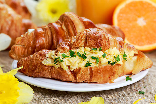 istock Summer Morning Breakfast Croissant stuffed scrambled eggs decorated with flowers. 519756514