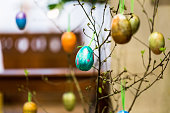 Colourful Hand-Painted Easter Eggs hanging from tree inside Church